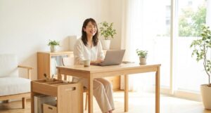 ナチュラルな書斎でノートPCを使う笑顔の女性とデスク横の木製収納ワゴンを写したデスク横収納の参考イメージ